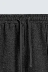 Pantalón de corte wide fit en tejido con acabado cepillado, color gris oscuro. Presenta cintura elástica con cordón ajustable, bolsillos delanteros y bolsillos traseros de plastrón.