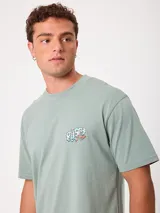 Remera negra de ajuste holgado con gran estampado gráfico en la espalda de temática tropical con una playa, palmeras y la inscripción "Welcome to Surfers Paradise".