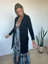 Saco de hilo de seda y lycra, color negro, de corte largo con bolsillos laterales con detalles de cierres y tiradores metálicos.