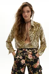 Camisa de terciopelo con estampado floral en tonos mostaza, cuello camisero clásico, cierre frontal con botones y mangas largas.