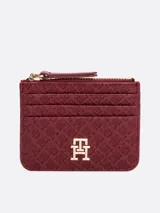 Tarjetero Tommy Hilfiger color borgoña con monograma TH en bajo relieve, compartimento con cremallera y múltiples ranuras exteriores para tarjetas.