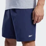 Short deportivo Reebok para hombre, color azul marino, confeccionado en nylon, con pretina elástica y cordón interno ajustable. Presenta bolsillos laterales y un bolsillo de parche trasero.