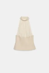 Top halter combinado con cuello subido ajustable mediante botones y hombros descubiertos, de diseño bicolor en tonos beige y blanco con sutiles rayas verticales.