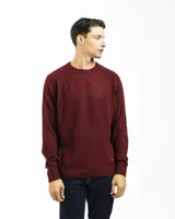 Buzo tejido de punto con cuello redondo, manga larga y puños y ruedo acanalados. Presenta un diseño clásico y versátil con un pequeño detalle de etiqueta en el lateral inferior.