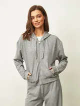 Campera negra con capucha, cierre frontal, mangas largas con puños elásticos y bolsillos laterales.