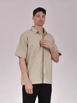 Camisa verde de manga corta con cuello clásico y cierre frontal con botones.