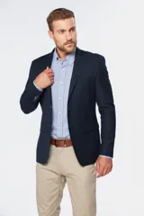 Saco sport azul marino de corte slim fit, con solapas de muesca, cierre de un botón y bolsillos ribeteados.