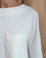 Remera de manga larga color marrón chocolate, con cuello redondo y dos bolsillos frontales tipo parche.