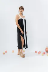 Vestido midi negro con panel frontal blanco, de corte amplio, escote recto y tiras anchas.