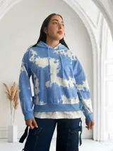 Buzo celeste con efecto tie-dye blanco, con capucha y cordones ajustables.