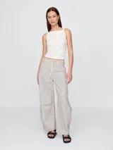 Jean de corte horseshoe con diseño de rayas verticales, tiro alto y cintura con cordón ajustable. Presenta una silueta amplia y estructurada con costuras laterales marcadas.