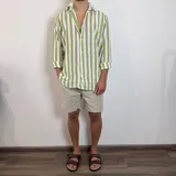 Camisa de lino de corte oversize con diseño de rayas verticales en tonos blanco y tostado, manga larga y cierre frontal con botones.