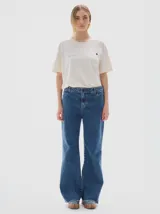 Jean de corte flare con tiro medio, confeccionado en denim de algodón con lavado vintage y desgaste en costuras. Presenta costuras en hilo color oro.