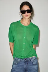 Chaqueta de punto de manga corta y cuello redondo en color verde, con cierre frontal de botones.