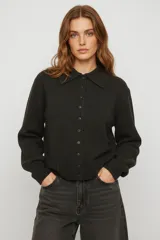 Saco de punto con cuello tipo camisa y cierre frontal de botones. Presenta mangas largas con puños acanalados y un diseño de calce recto.