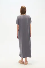 Vestido midi de corte holgado, color negro, con mangas cortas, cuello en V y detalle de cuentas decorativas en el escote.