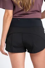 Short negro de tiro medio con corte ligeramente acampanado, confeccionado en tejido técnico de secado rápido con cintura elástica ancha.