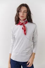 Remera blanca de manga larga con cuello redondo y costuras decorativas en contraste de color negro.