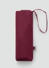 Paraguas plegable compacto color bordó, con funda a juego y tira para collar en la muñeca.