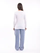 Remera negra de manga larga con escote en V y estampa frontal blanca con diseño de soles y la frase 'Woke Up'.