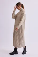 Vestido midi de punto canale color beige, con cuello alto y mangas largas, de corte recto y ajustado.