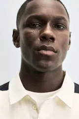 Sudadera de manga larga estilo polo con diseño de rayas horizontales anchas en azul marino y blanco. Presenta cuello de solapa en contraste, cierre frontal con botones ocultos y acabados en rib en puños y bajo.