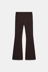 Pantalón de vestir color rosado, tiro bajo, con corte acampanado (flare) y costuras laterales marcadas. Cierre frontal con botón interior y gancho.