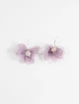 Aros colgantes con diseño de flor grande confeccionada en tela de organza color lila, con centro decorado con cuentas brillantes y cierre de gancho metálico.