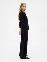 Pantalón de tiro medio y corte recto, confeccionado en terciopelo negro con cintura elástica y bolsillos laterales.