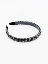 Vincha rígida forrada en tela gris, decorada con múltiples cuentas facetadas de color negro que cubren toda la superficie superior.