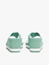 Ojotas de cuña con plataforma de 6,8 cm, color verde menta con rayas blancas horizontales en la plataforma. Las tiras son de tejido trenzado con el logo de Tommy Hilfiger repetido.