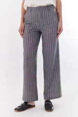 Pantalón de vestir marrón claro con finas rayas verticales blancas, de corte recto y relajado.