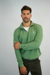 Buzo de algodón de punto en color verde, con cuello alto y cierre frontal parcial. Presenta puños y ruedo acanalados, con un pequeño logo bordado en el pecho.