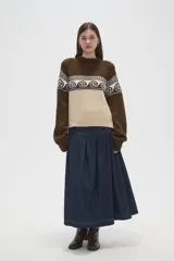 Sweater de tejido de punto con diseño jacquard, cuello redondo y mangas largas. Presenta una combinación de bloques de color marrón y beige con un patrón geométrico y de espirales en la parte superior.
