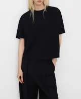 Camiseta de algodón negro, con cuello redondo, mangas cortas y corte holgado evasé.