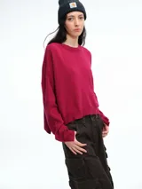 Sweater de tejido de punto color beige, con cuello redondo, hombros caídos y costura central vertical en el frente. Presenta un diseño de corte relajado, con largo asimétrico y aberturas laterales en el ruedo.