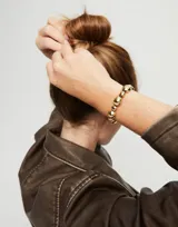 Pulsera de cuero marrón con cuentas medianas y pequeñas de aleación de metales bañadas en oro de 18k.