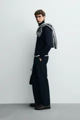 Jersey negro de punto fino con cuello alto y manga larga.