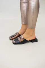 Mules de cuero color beige con detalles en marrón y suela de madera.