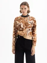 Buzo de rústico con estampado full print en tonos marrones y beige, cuello redondo tejido en color chocolate y puños y cintura tejidos en beige. De calce amplio y mangas largas.