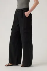 Pantalón cargo negro de corte ancho, con bolsillos laterales con solapa y cintura con cinturón ajustable con hebilla metálica.