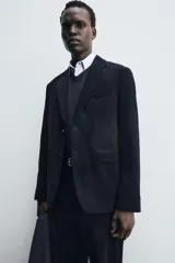 Blazer de corte relajado confeccionado en pana de algodón. Presenta cuello con solapas de muesca, cierre frontal con botones, bolsillo de vivo en el pecho y bolsillos con solapa en la cadera. Incluye aberturas en la espalda y puños con botones.