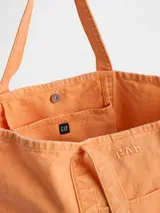 Bolso tote Gap color naranja tangerine, confeccionado en lona con doble asa de hombro, bolsillo frontal abierto y logo de la marca bordado.