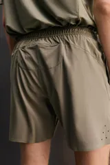 Short deportivo de entrenamiento color marrón, confeccionado en tejido técnico ligero y elástico. Cuenta con cintura elástica ajustable con cordón, bolsillos frontales, bolsillo trasero con cierre y aberturas laterales en el bajo. Incluye detalle de logo estampado en la pernera.