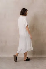 Vestido midi camisero de corte oversize color blanco, con cierre frontal de botones, mangas cortas con vuelta y ruedo redondeado.