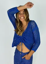 Top tejido calado color azul eléctrico, con escote en V y cordón ajustable en el centro.