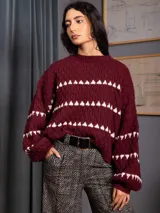 Buzo corto de tejido de punto en color negro, con diseño de textura en relieve y líneas horizontales blancas. Presenta cuello redondo y mangas largas con puños ajustados.