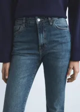 Jeans slim tiro alto de color azul, con diseño crop, cierre de botón y cremallera, trabillas y cinco bolsillos.