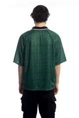 Remera deportiva verde con cuello polo negro con detalles de líneas blancas, mangas cortas con ribete negro y estampado con el logo de la marca en el pecho.