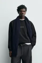 Sudadera de cuello redondo y manga larga, confeccionada en algodón con interior afelpado. Presenta un diseño de corte regular con estampado de texto en contraste en la parte frontal y acabados en rib en puños y ruedo.